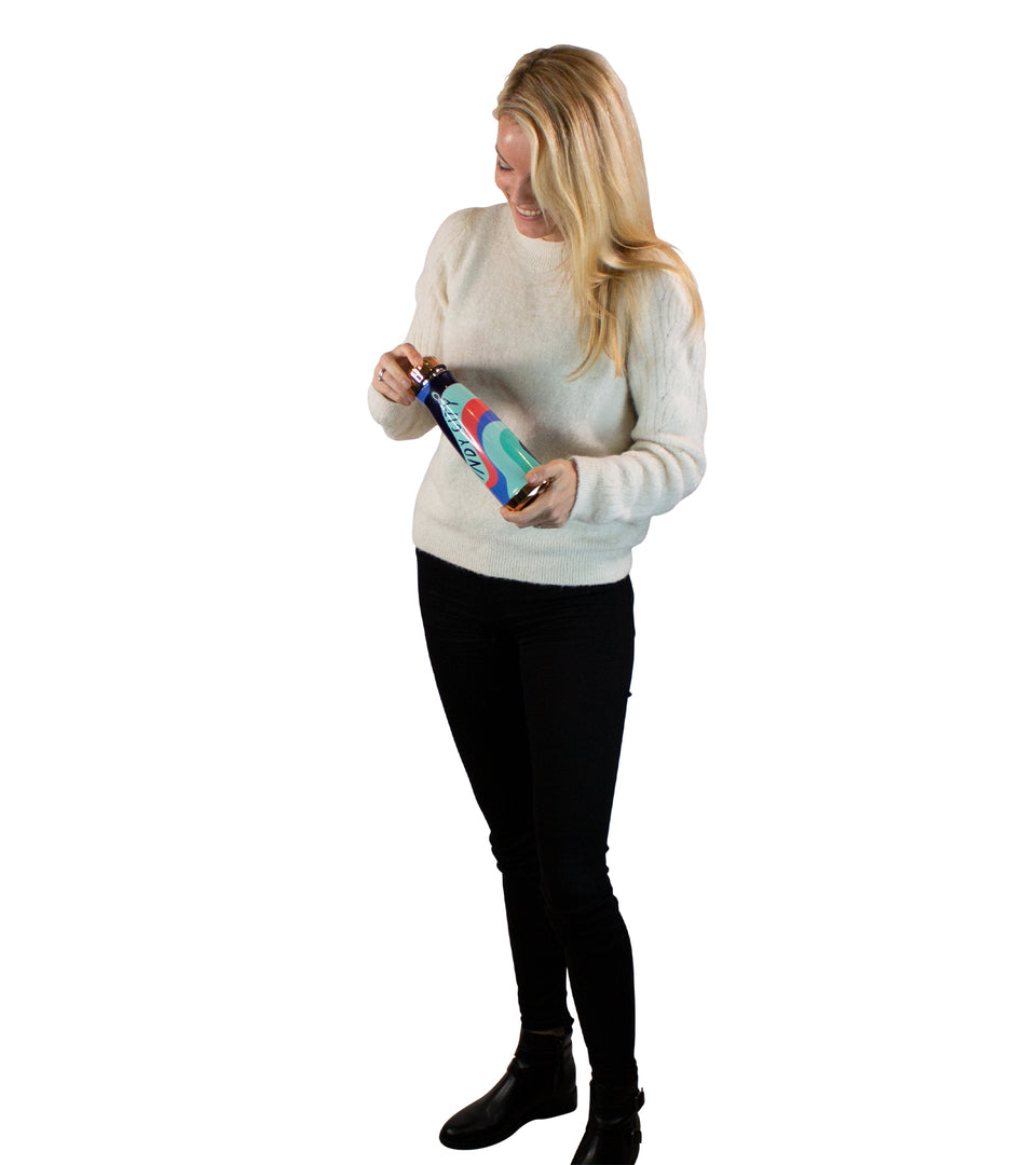 Standing female model holding metal bottle with black, blue, mint, & coral waves, black Windy City text, gold-tone cap & base